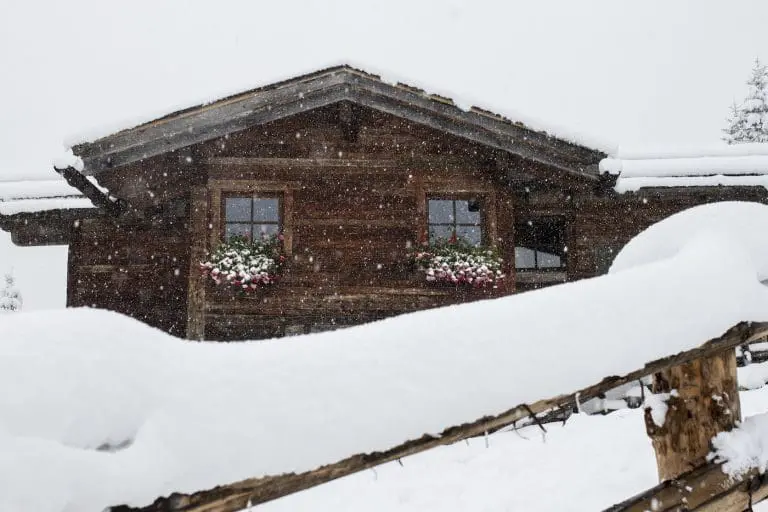 Sneeuw op hek bij huis