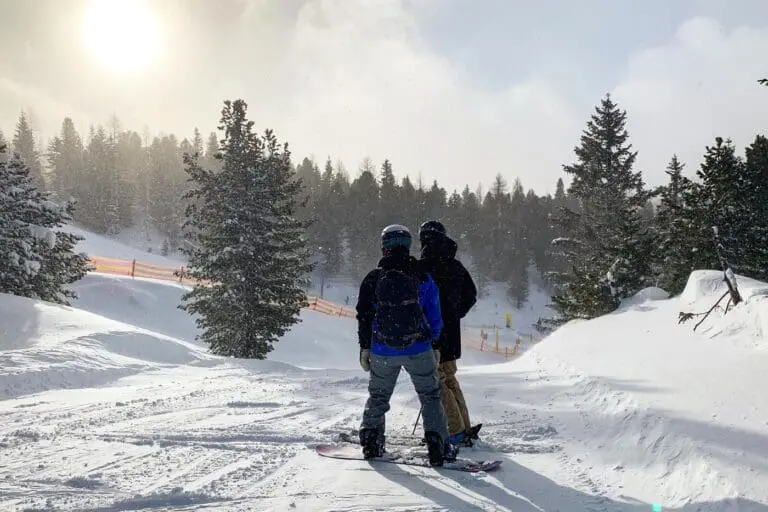 Skiër en snowboarder op de piste
