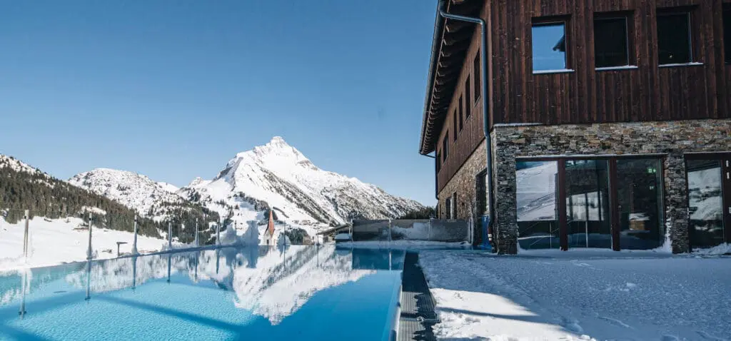 PURE Resort Warth met infinity pool met uitzicht op de bergen