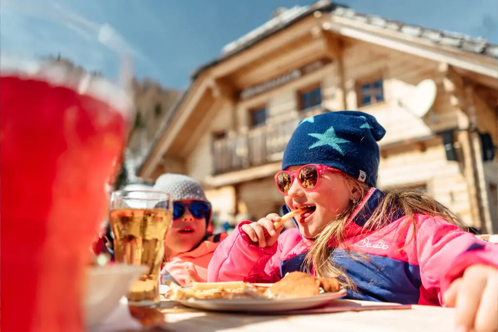 Kind etend bij een skihut