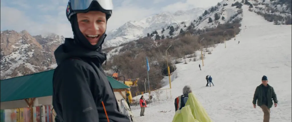 Paul de Groot lachend in de stoeltjeslift in een skigebied in Oezbekistan