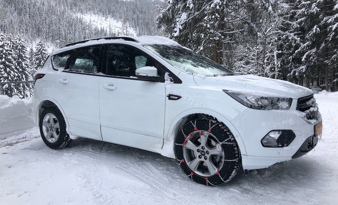 Auto auf Schneeketten im Schnee beim Skiurlaub