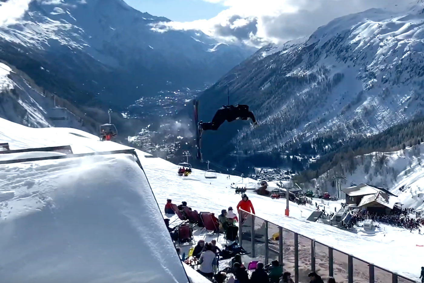 Skiër doet salto over berghut