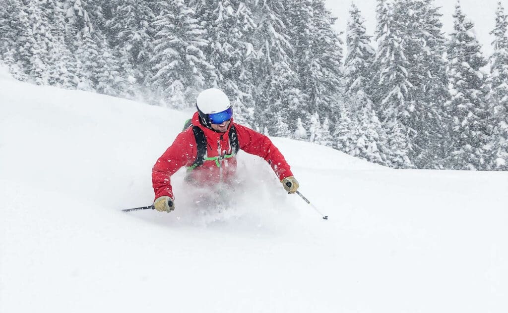 Skifahren abseits der Piste mit Lawinenausrüstung im Pulverschnee